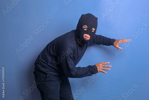 Photography Thief with a black mask on his face sneaks forward and get caught