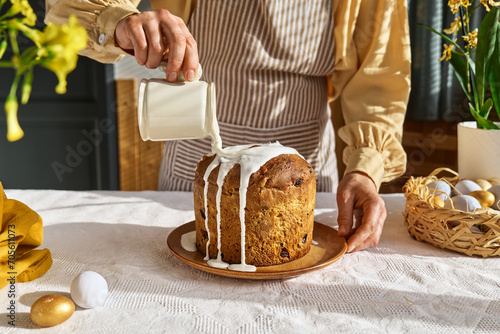 Canvas Print Female hands pouring icing on Easter cake