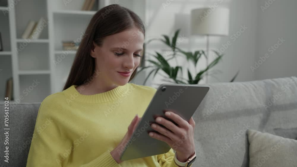Happy Caucasian Lady Relaxing at Home on Couch Using Digital Tablet. Young Woman Surfing Internet, Studying Online. People and Technology Concept Happy Caucasian Lady Relaxing at Home on Couch Using Digital Tablet. Young Woman Surfing Internet, Studying Online. People and Technology Concept