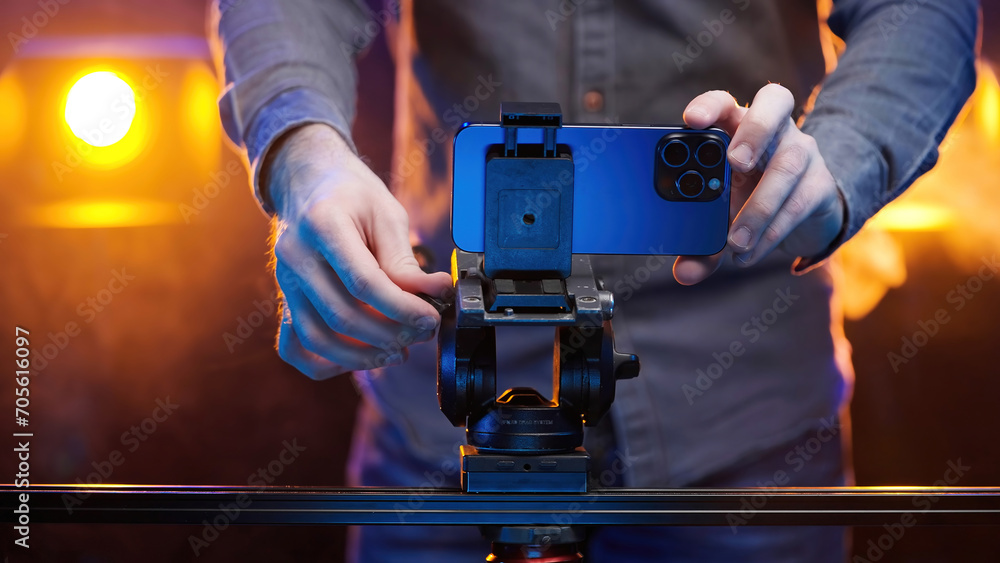 Creative filmmaker put a smartphone on tripod head with slider Creative filmmaker put a smartphone on tripod head with slider