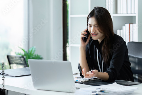 Businesswoman on the phone and using laptop at office. Businesswoman professional talking on mobile phone