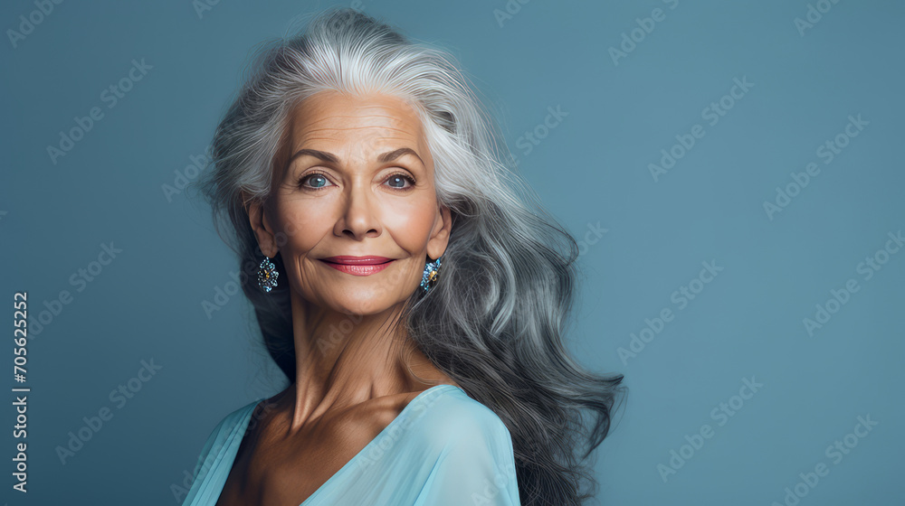Elegant, smiling, elderly, chic, woman with gray long hair and perfect skin, on a blue background, banner.