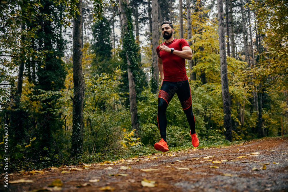 Fit sportsman is running in nature on rainy weather in nature. Fit sportsman is running in nature on rainy weather in nature.