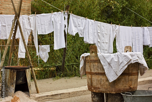 Ancient vat of laundry, brazier and old underwear and sheets hanging to dry. Laundry hung out, clothesline with ancient linen