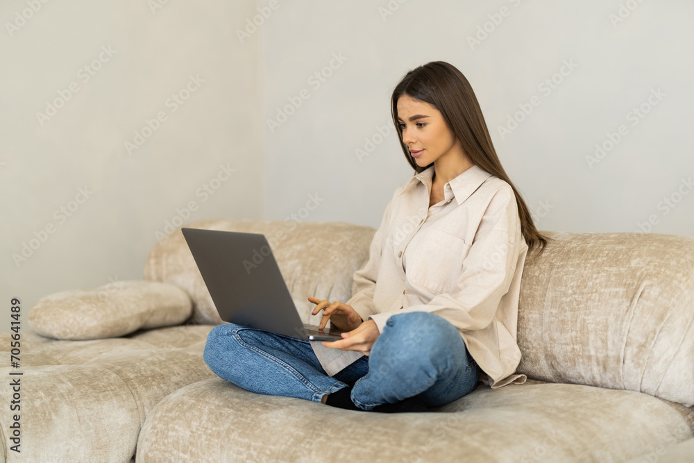 Beautiful woman with laptop resting on couch at home Beautiful woman with laptop resting on couch at home
