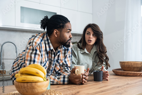 Business colleagues talk during lunch break in office kitchen. Woman communicates with workmate hold coffee cups enjoy conversation, discuss work or personal. Good relations at work concept photo