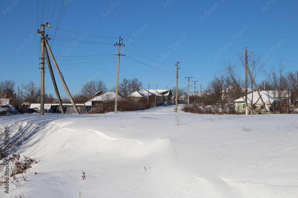 A snowy road with power lines