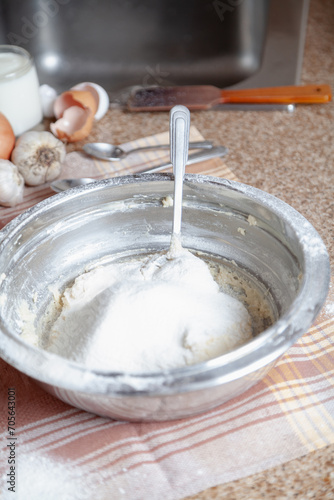 Bowl with flour and spoon on a napkin....