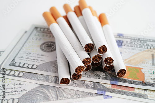 Cigarette on US dollar banknotes, cost, trading, marketing and production, No smoking concept.