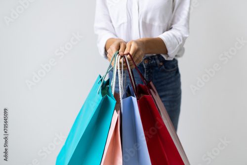 Woman hand holding shopping bags isolated on white
