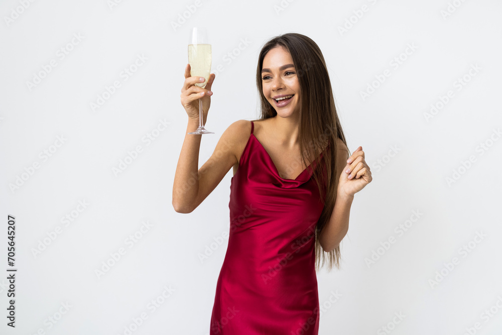 Young celebrating woman in red dress . Beautiful model portrait isolated over white background hold wine glass. Young celebrating woman in red dress . Beautiful model portrait isolated over white background hold wine glass.