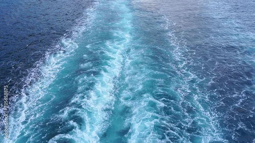 Blue stern waves on the ocean, beautiful pattern on the foamy water surface. 4k photo