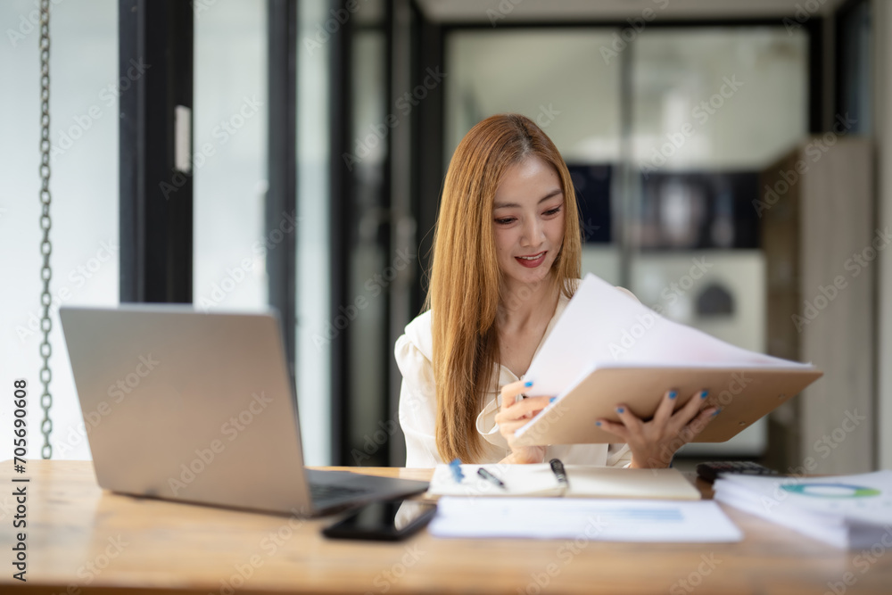 Business woman sitting and working using laptop, searching and checking information Business woman sitting and working using laptop, searching and checking information