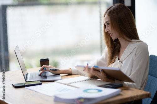 Business woman sitting and working using laptop, searching and checking information