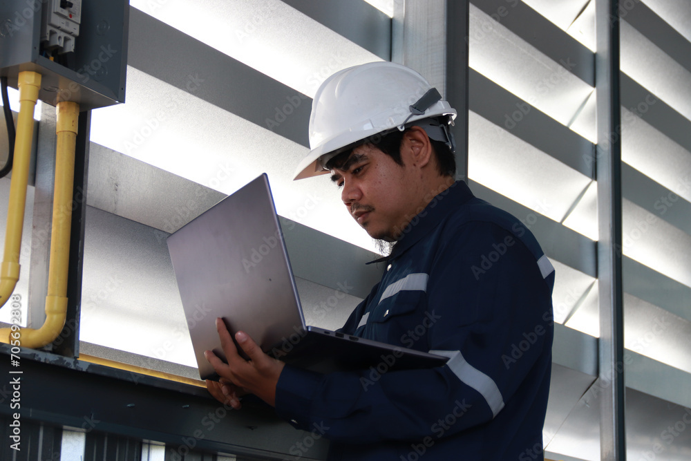 custom made wallpaper toronto digitalChief engineer in hard hat walks through modern factory lighting while holding laptop. Successful handsome man in modern industrial environment.