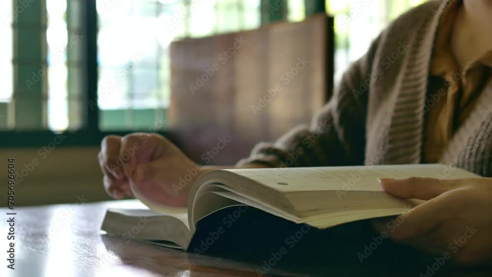 Learning, education Hand of Senior woman standing holding a book in library by the window in the morning, relax and enjoy books. Learning, education Hand of Senior woman standing holding a book in library by the window in the morning, relax and enjoy books.