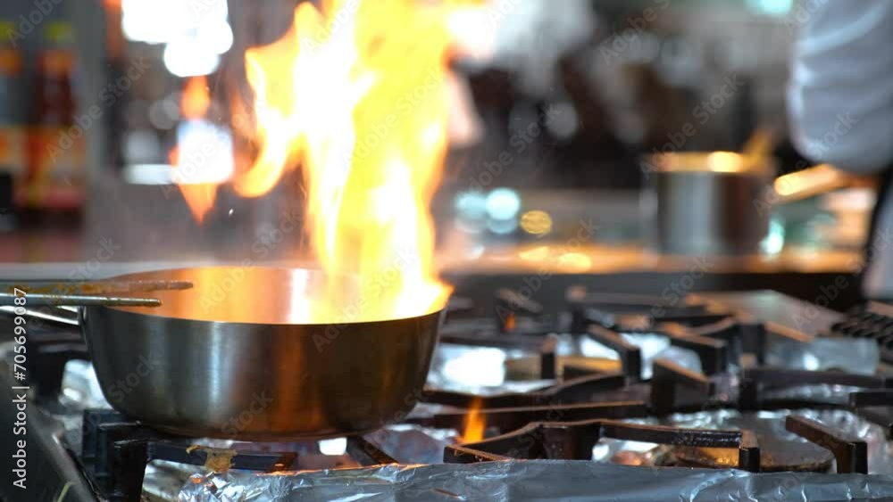 Close-up of a Restaurant Chef Cooking Food on Fire in the Restaurant Kitchen Close-up of a Restaurant Chef Cooking Food on Fire in the Restaurant Kitchen