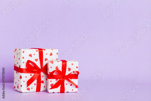 gift box with red bow and red heart on colored background. Perspective view. Flat lay