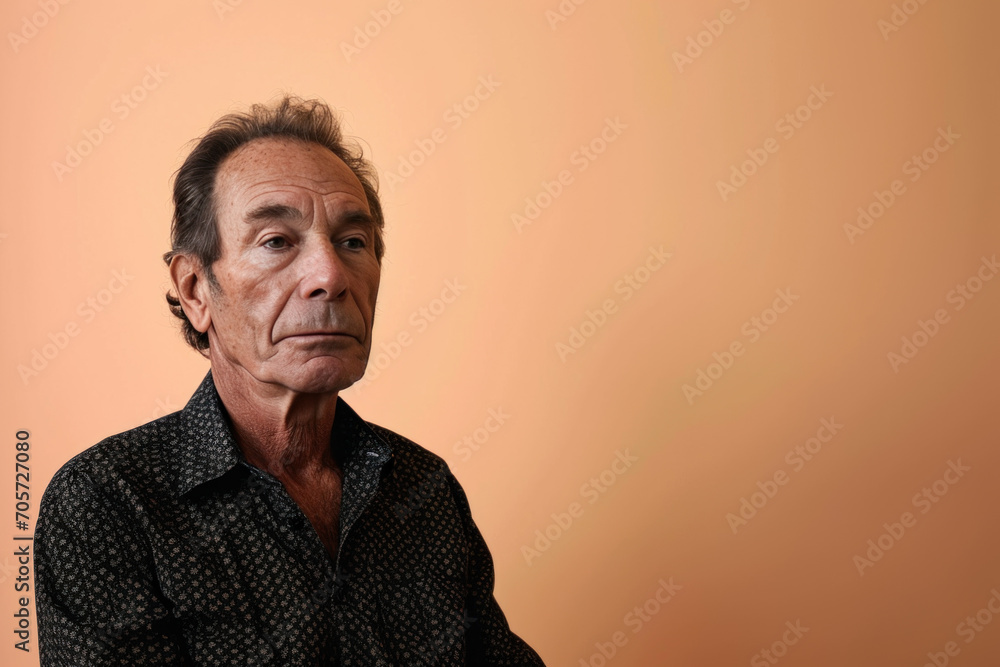 Obraz premium portrait studio sur fond orangé d'une homme de 50-60 ans