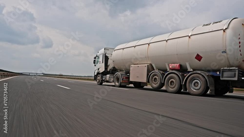 Rolling shot of tank truck with gasoline, gas or other fuel, oil trailer driving on highway. Transportation by land, cargo and oil delivery