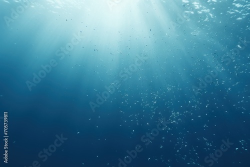  a blue ocean with a lot of bubbles on the water and sunlight shining down on the water and the bottom part of the water is blue and the bottom half of the water.