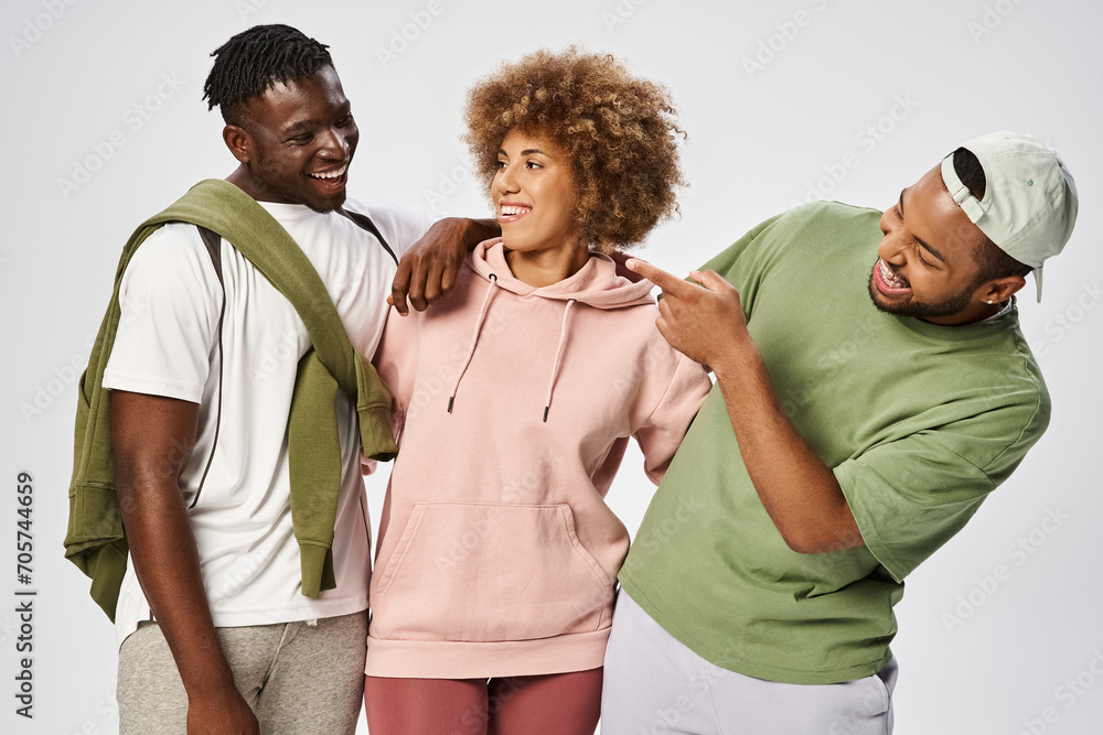 Fototapeta premium positive african american friends standing together on grey background, Juneteenth celebration