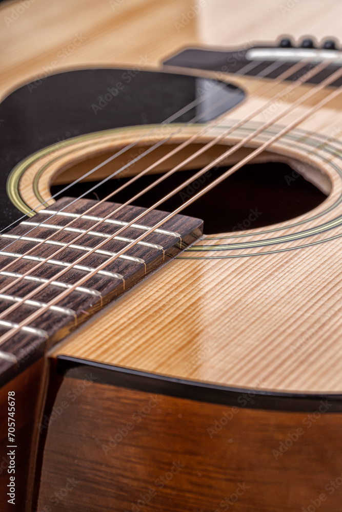 Fototapeta premium Classical guitar close up. Acoustic guitar on wood background.Music instrument concept