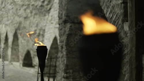 Two torches burn before a medieval palace.Flame of torches at the gate of the fortress. Burning flambeaus in winter fell castle. The flame of brands develops in the wind. Slow motion. 
