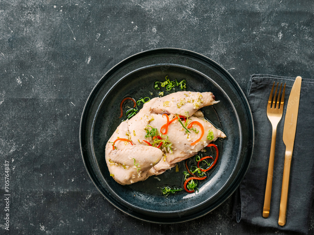 Sous Vide Chicken with spices. Boiled chicken sous-vide on black plate. Sous-vide is culinary method of long-term cooking