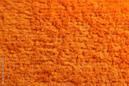  a close up of an orange carpet textured with a lot of small holes in the middle of the area that looks like it has been made out of a blanket.