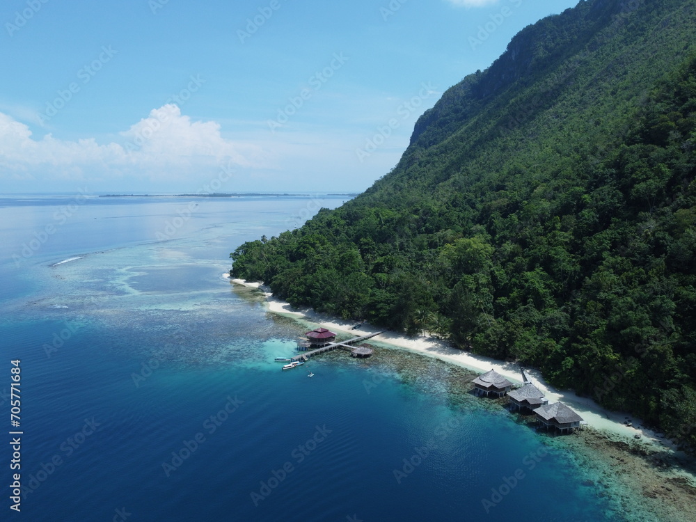 Idyllic island paradise with tranquil turquoise waters and lush greenery in ora beach, Maluku, Indonesia Idyllic island paradise with tranquil turquoise waters and lush greenery in ora beach, Maluku, Indonesia