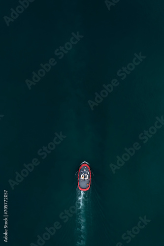 Aerial view to a small red ship in the sea