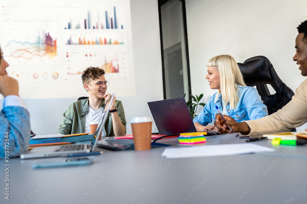 Diverse group of young business people working on new project together in office. Diverse group of young business people working on new project together in office.