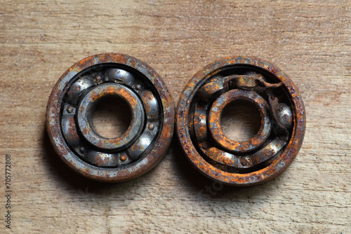 old rusty and damaged  ball bearing on wood  table .  corrosion of steel . rusty ball bearing photo