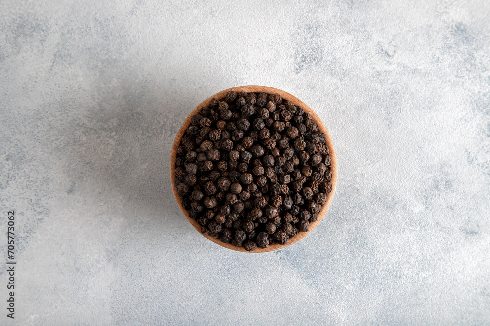 Black peppercorns in wooden bowl,top view Black peppercorns in wooden bowl,top view