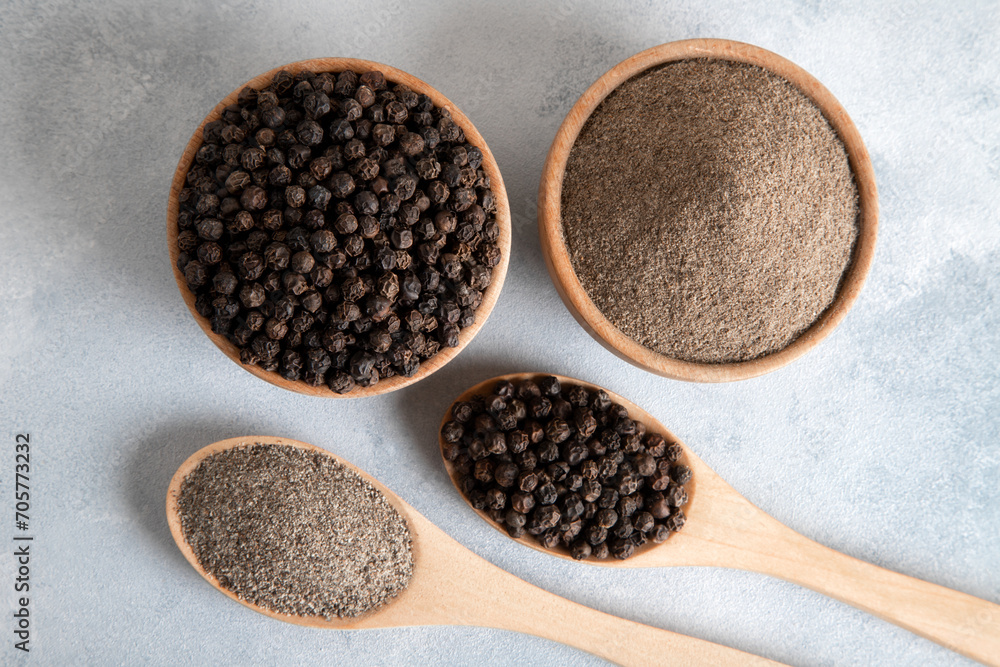 Ground black pepper with grains of black pepper on bright background Ground black pepper with grains of black pepper on bright background