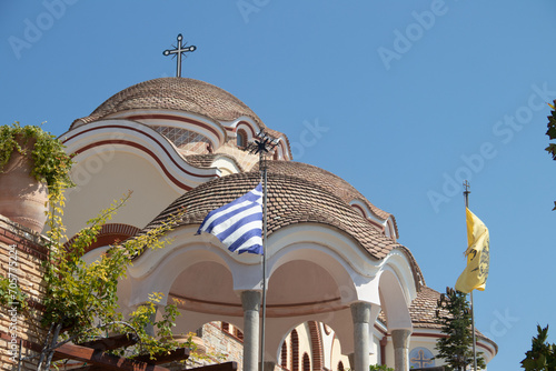 View on backyard of Monastery of Archangel Michael in Greece, Thasos Island, with vivid orange walls and roof, monastery was build at the cliff over the Aegean Sea, which first began as a men's only  photo