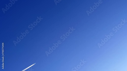 Jet contrail crossing the clear blue sky. Cloudscape. photo