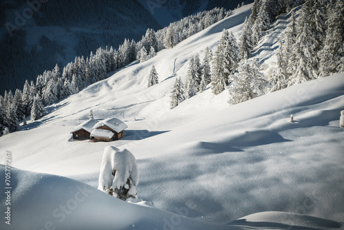 Winterlandschaft im Zillertal mit Skihütten auf einer Waldlichtung
