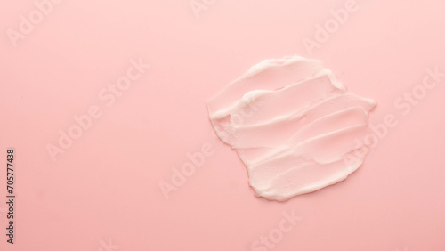 Skincare cream smear on pink background. Cosmetic lotion swatch texture of face cream, body moisturiser and hair conditioner. Banner or template for beauty and cosmetic product.