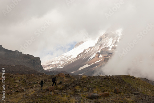 Couple hiking on mountain in Georgia Caucasus muntains on summer day with peaks and snow