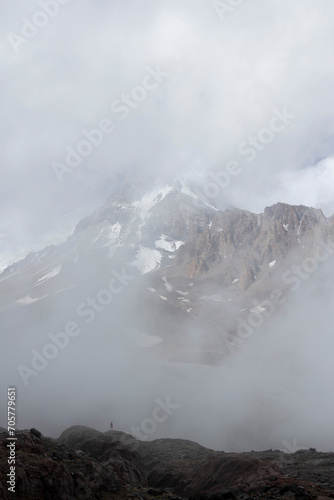Silhouette of mountain climber in Georgia Caucasus mountains against foggy landscape of mount Kazbek © Barosanu
