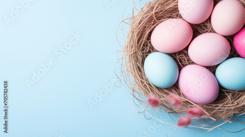 Easter nest with eggs in pastel blue and pink colors on a blue background