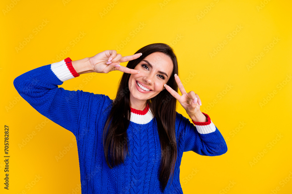 Portrait of young optimistic brunette hispanic model woman gesture v sign pray for ukrainian victory isolated on yellow color background Portrait of young optimistic brunette hispanic model woman gesture v sign pray for ukrainian victory isolated on yellow color background