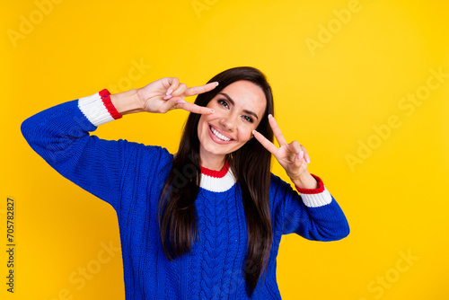 Portrait of young optimistic brunette hispanic model woman gesture v sign pray for ukrainian victory isolated on yellow color background