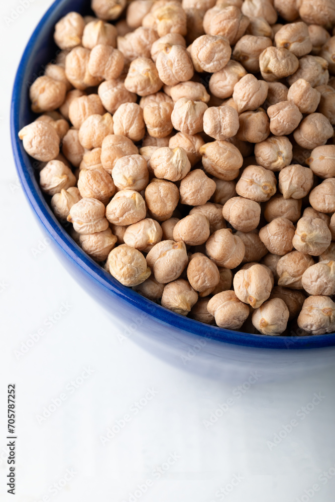 Dried chickpeas in blue ceramic bowl on white background Dried chickpeas in blue ceramic bowl on white background