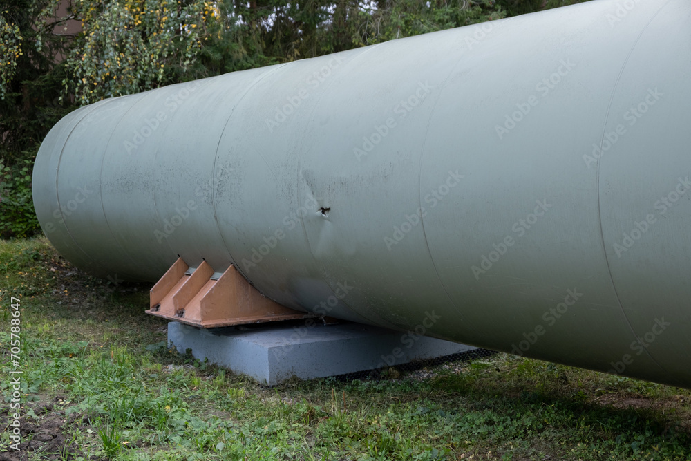 A colossal tube represents a thermal energy transfer infrastructure, central heating pipes enveloped in a robust metal thermal insulation jacket. Above-ground in European distribution energy