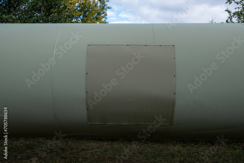 A colossal tube represents a thermal energy transfer infrastructure, central heating pipes enveloped in a robust metal thermal insulation jacket. Above-ground in European distribution energy