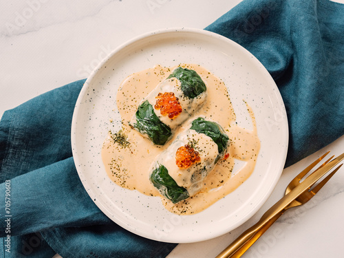 фотографія Stuffed green cabbage rolls with sauce in restaurant-style plating, served red c