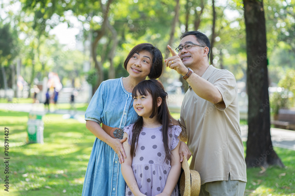 Happy Asian family enjoying leisure time with outdoor activities in a public park.